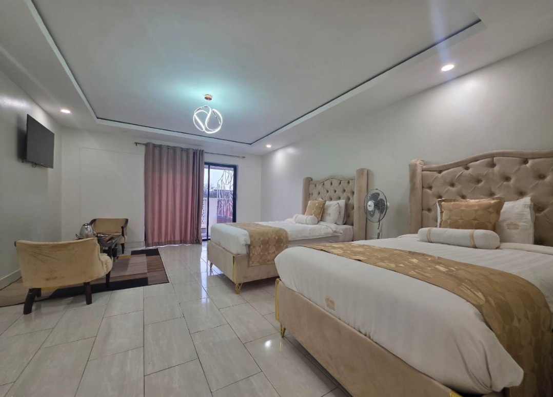 Greys Inn Hotel Deluxe Room with two beds, armchairs and a television